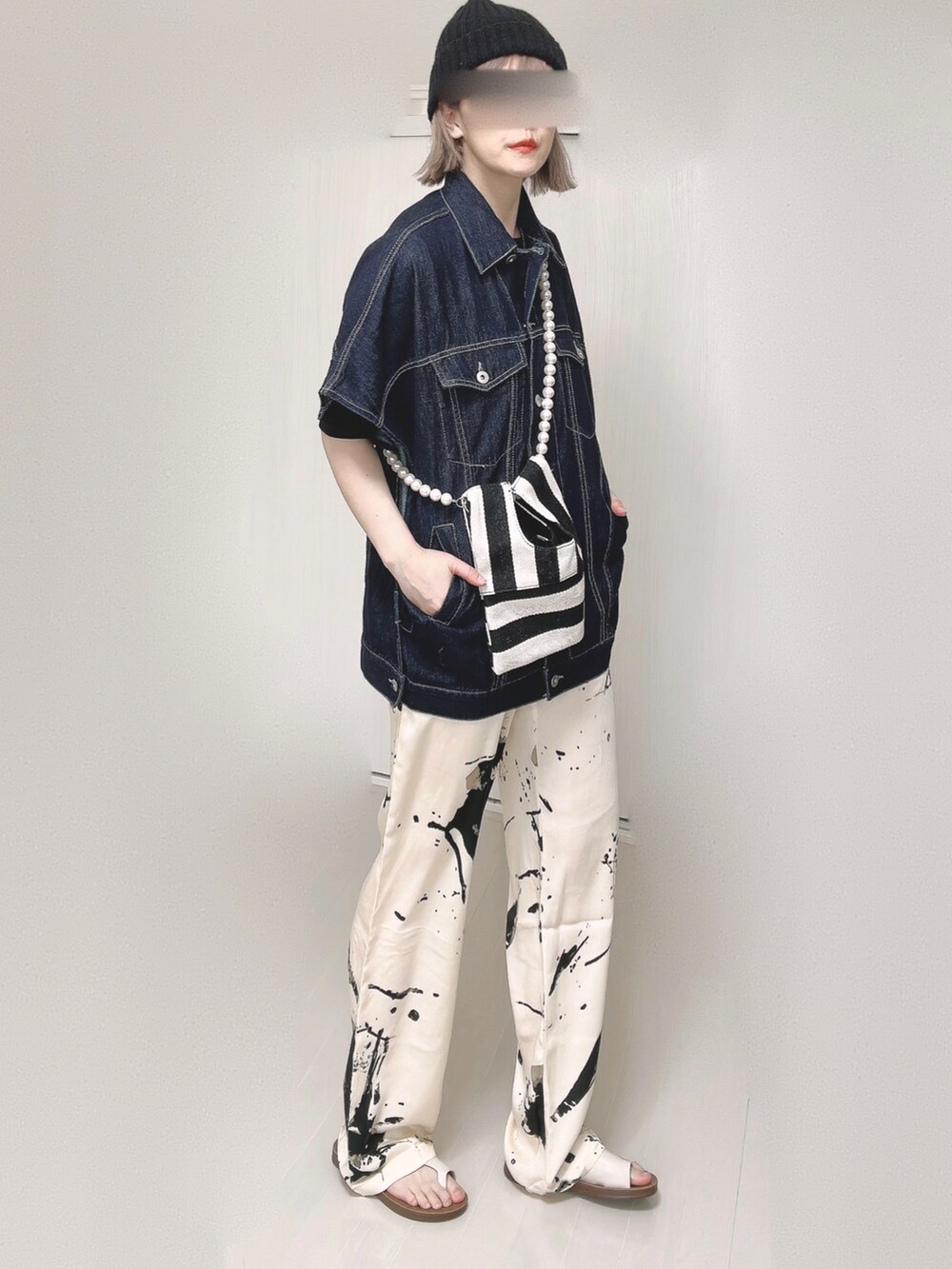 ブルー系のベスト、ブラック系のTシャツ/カットソー、ホワイト系のショルダーバッグを着用したレディースの春コーディネートの4枚目の写真