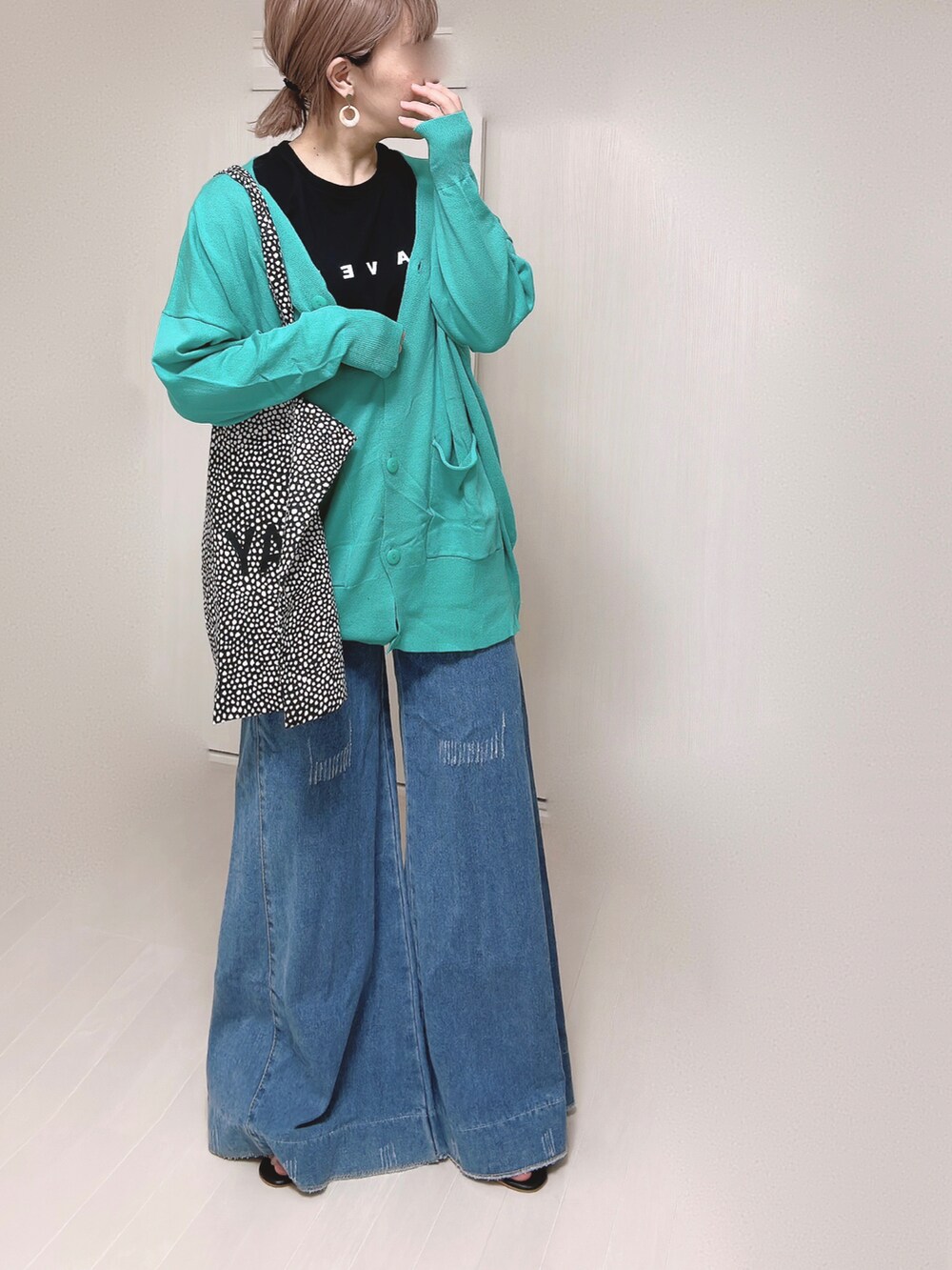 グリーン系のカーディガン/ボレロ、ブラック系のTシャツ/カットソー、ブラック系のサンダルを着用したレディースの春コーディネートの2枚目の写真