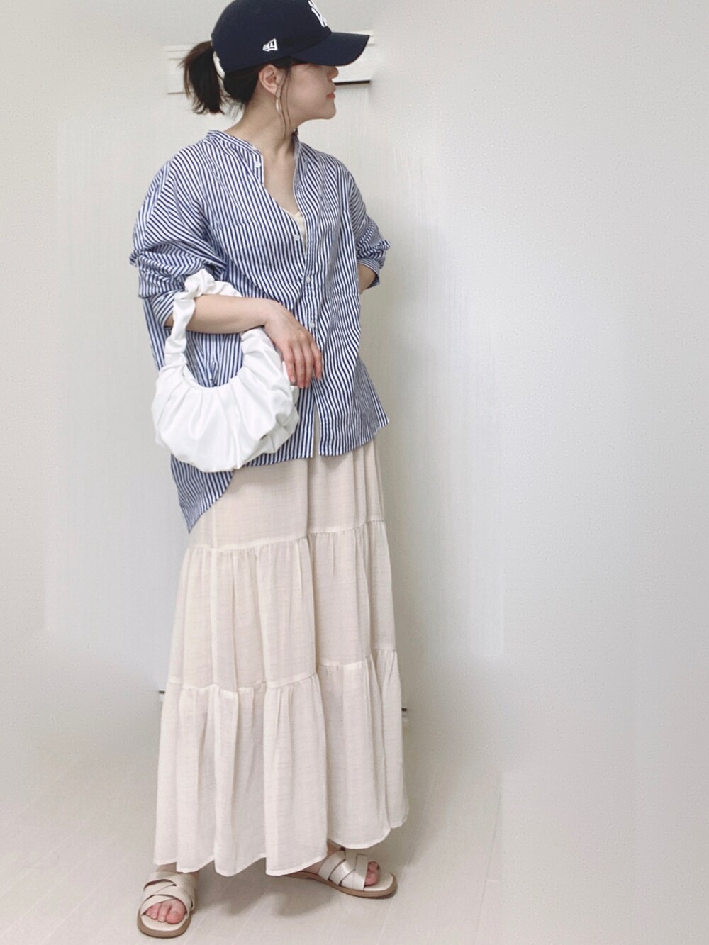 ホワイト系のキャミソール、ホワイト系のスカート、ホワイト系のサンダルを着用したレディースの夏コーディネートの4枚目の写真