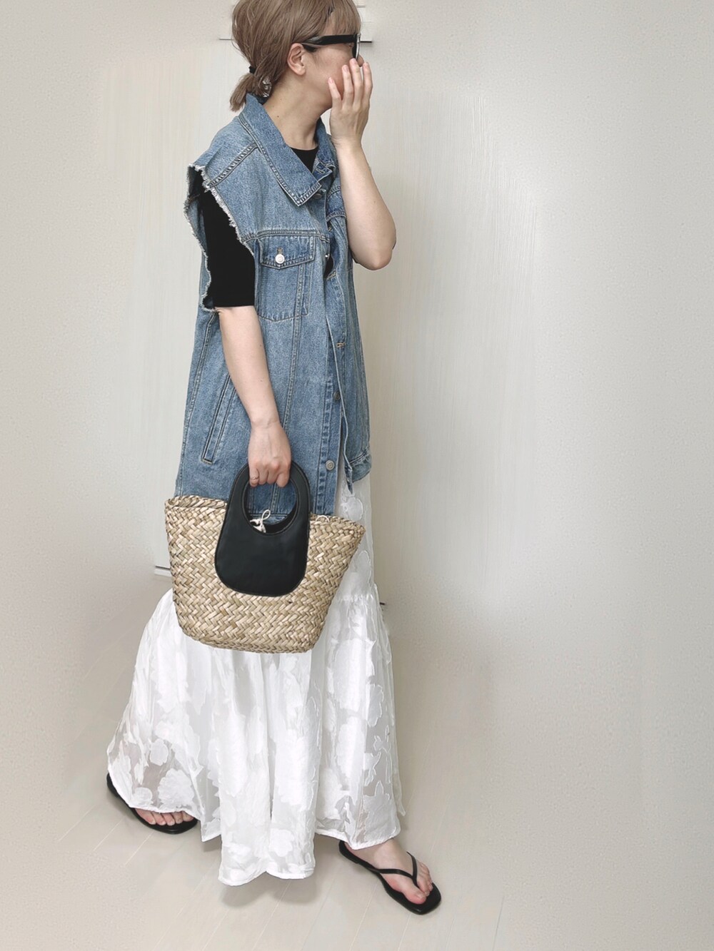 ホワイト系のスカート、ブラック系のTシャツ/カットソー、ブルー系のベストを着用したレディースの夏コーディネートの3枚目の写真