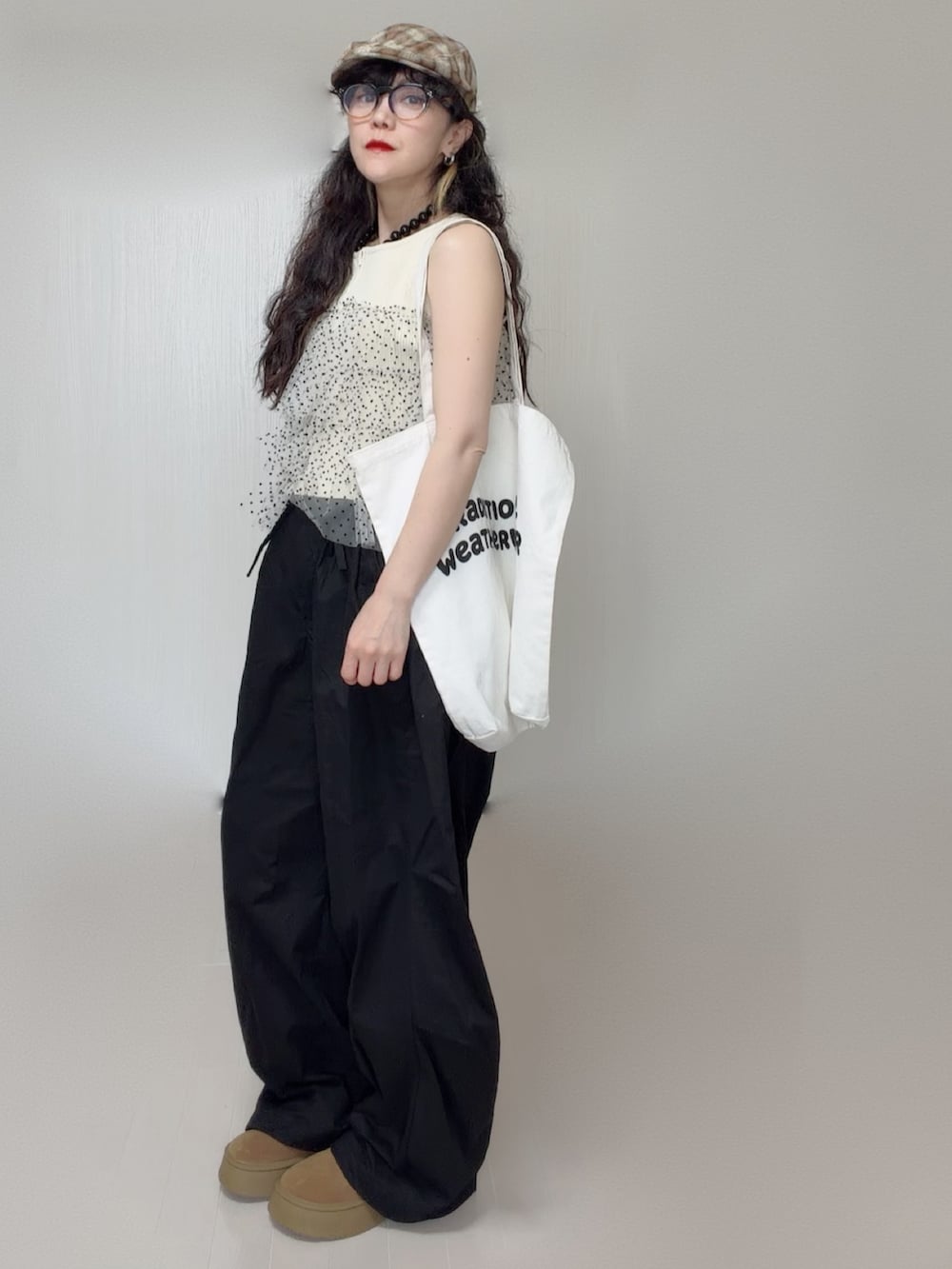 ホワイト系のニット/セーター、ブラック系のその他パンツ、ホワイト系のトートバッグを着用したレディースの夏コーディネートの3枚目の写真