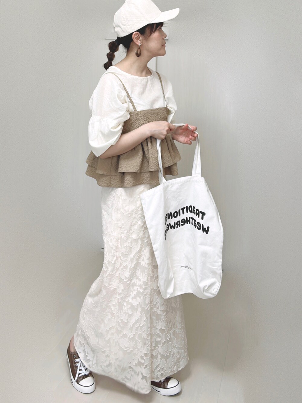 ホワイト系のスカート、ホワイト系のシャツ/ブラウス、ベージュ系のキャミソールを着用したレディースの夏コーディネートの3枚目の写真