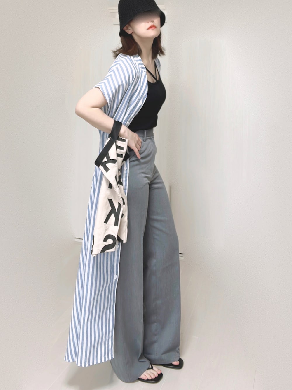 ブラック系のキャミソール、ブルー系のシャツワンピース、ホワイト系のトートバッグを着用したレディースの夏コーディネートの2枚目の写真