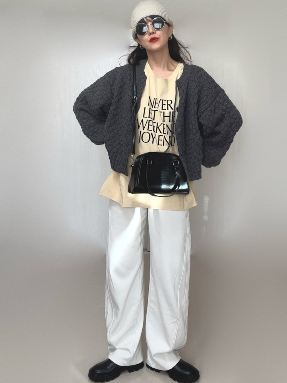 グレー系のニット/セーター、ブラック系のブーツ、ベージュ系のTシャツ/カットソーを着用したレディースの冬コーディネートの2枚目の写真