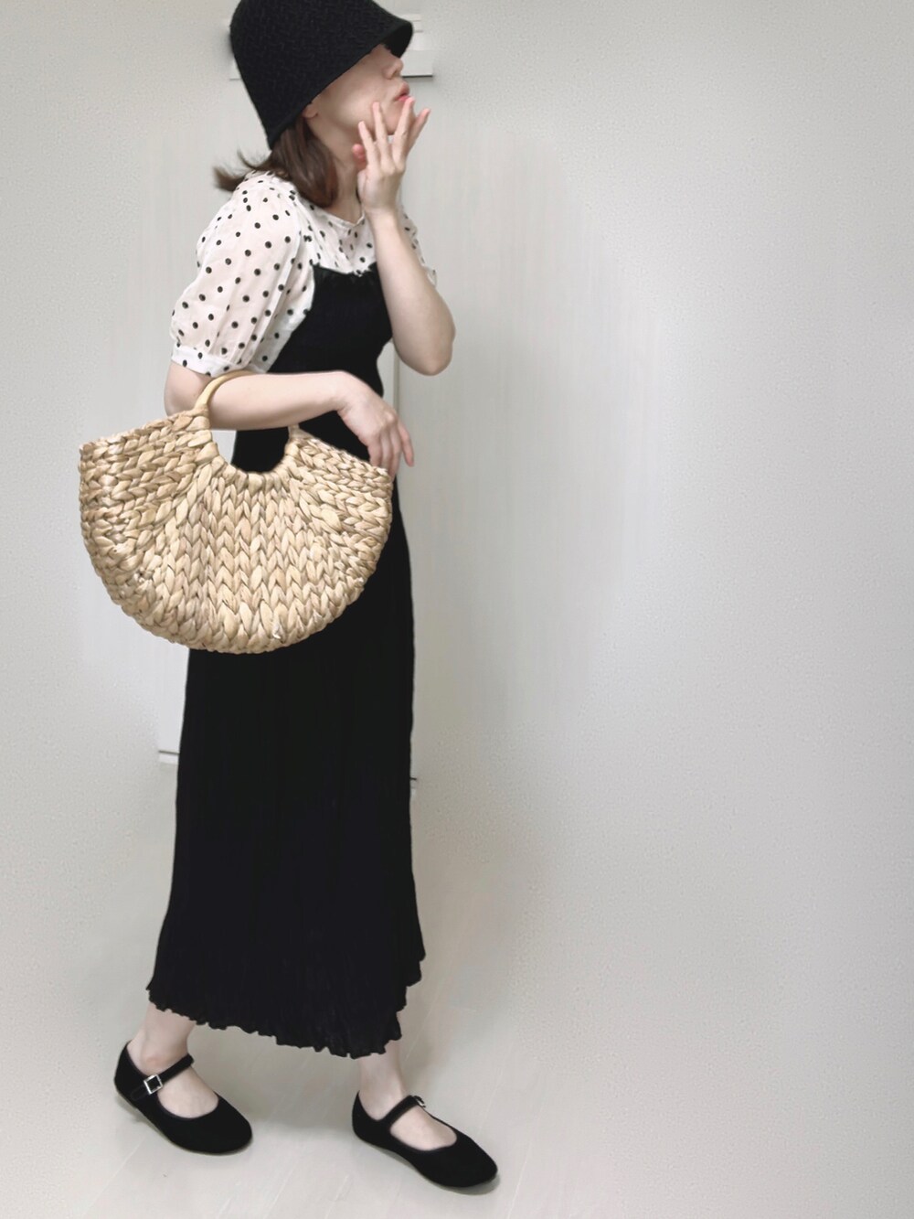 ベージュ系のかごバッグ、ブラック系のワンピース、ブラック系のパンプスを着用したレディースの夏コーディネートの4枚目の写真