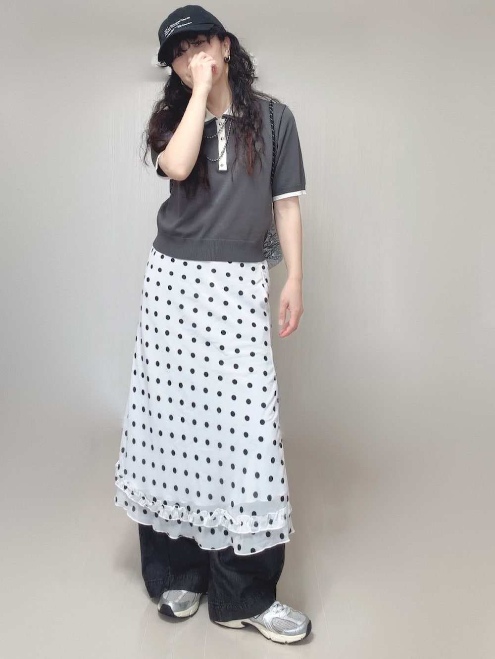 ブラック系のデニムパンツ、シルバー系のトートバッグ、グレー系のポロシャツを着用したレディースの夏コーディネートの2枚目の写真