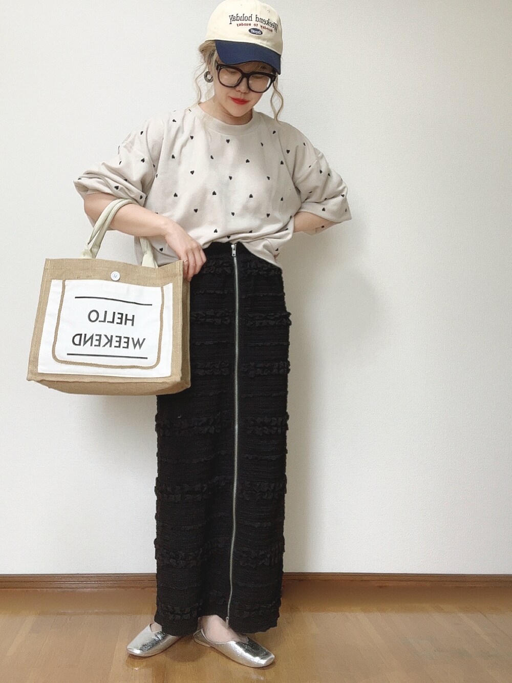 ブラック系のスカート、ホワイト系のかごバッグ、シルバー系のパンプスを着用したレディースの夏コーディネートの4枚目の写真