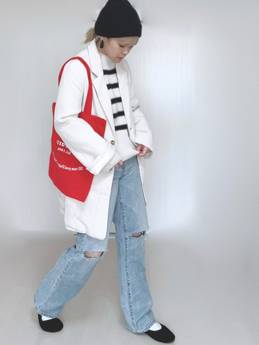 ホワイト系のテーラードジャケット、ホワイト系のニット/セーター、ブルー系のデニムパンツを着用したレディースの春コーディネートの5枚目の写真