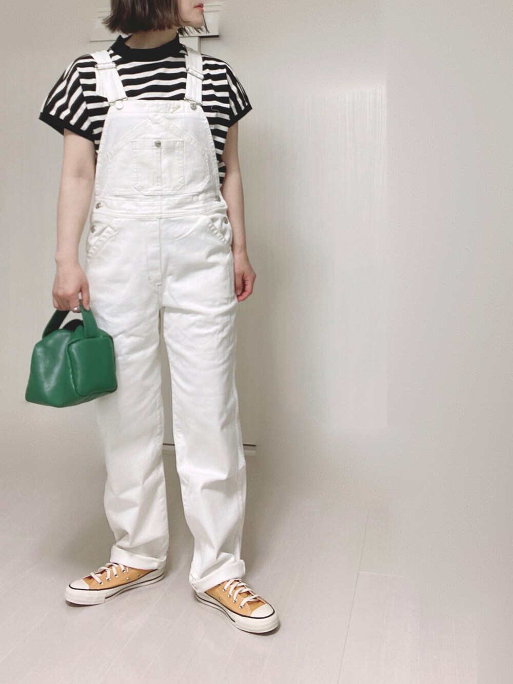 ホワイト系のTシャツ/カットソー、ホワイト系のサロペット/オーバーオール、グリーン系のハンドバッグを着用したレディースの春コーディネートの4枚目の写真