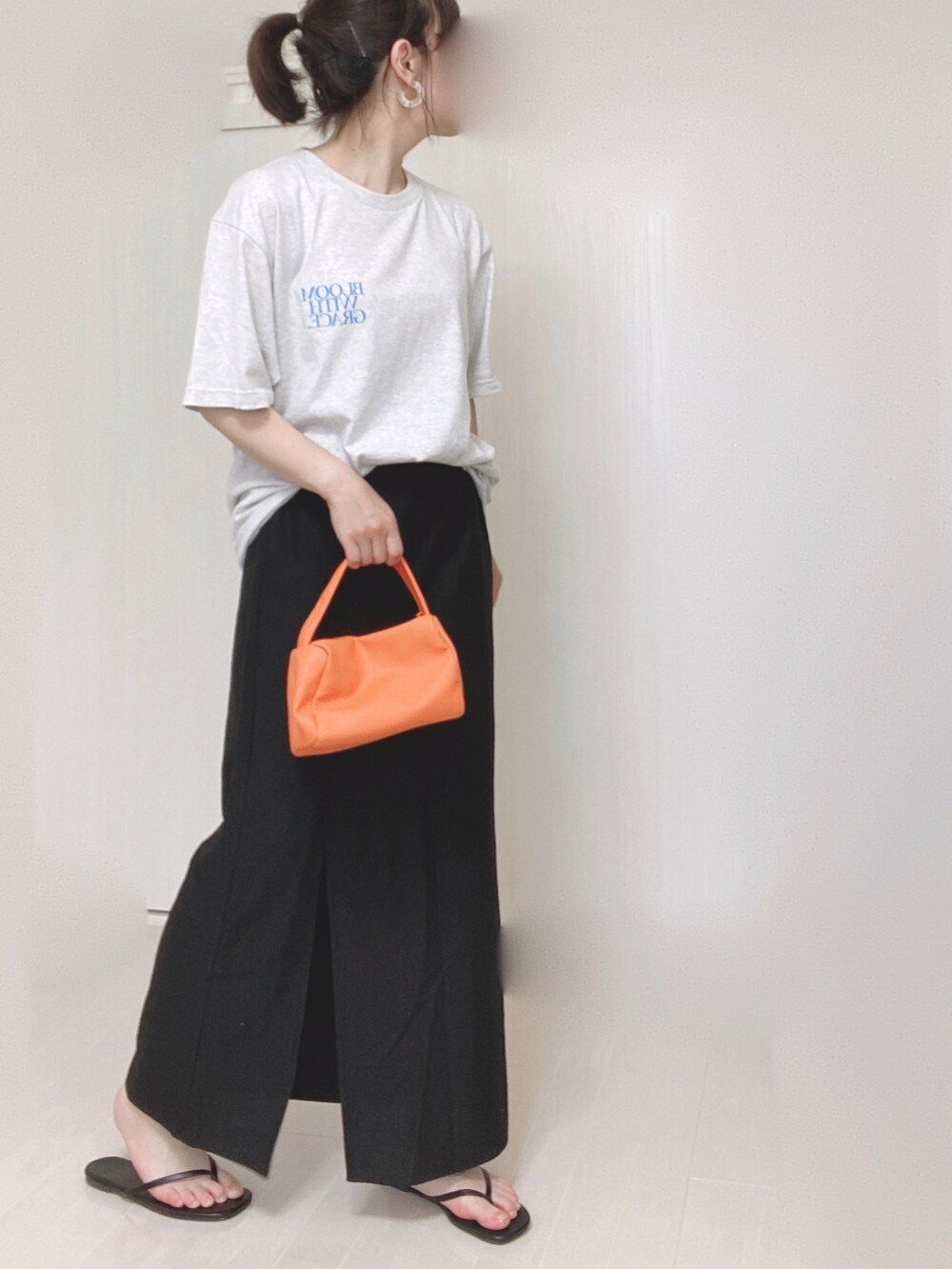 ベージュ系のTシャツ/カットソー、ブラック系のスカート、オレンジ系のショルダーバッグを着用したレディースの夏コーディネートの3枚目の写真