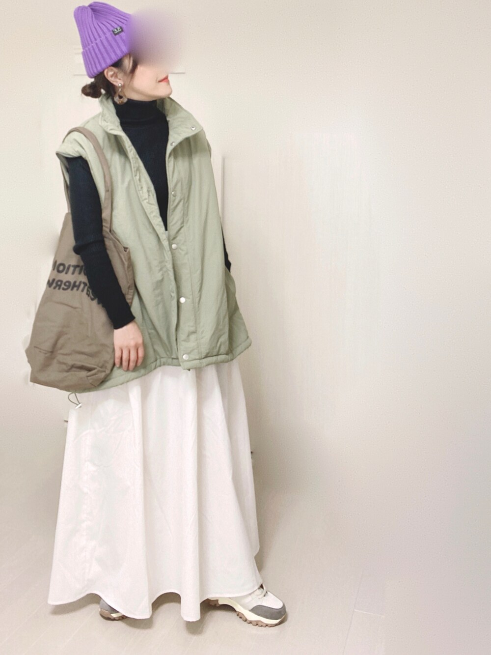 グリーン系のダウンジャケット/コート、ホワイト系のスカート、ベージュ系のスニーカーを着用したレディースの秋コーディネートの5枚目の写真