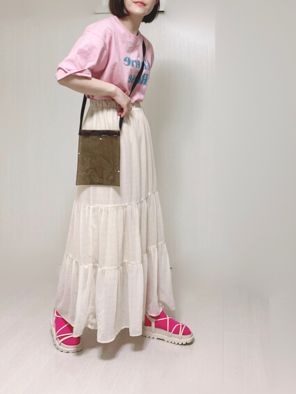 ピンク系のTシャツ/カットソー、ホワイト系のサンダル、ホワイト系のスカートを着用したレディースの夏コーディネートの2枚目の写真