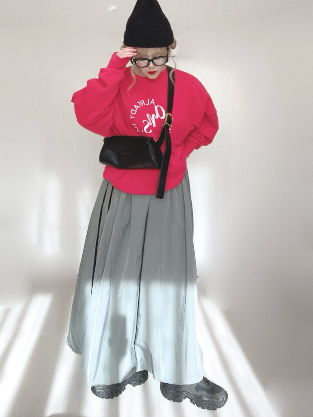 レッド系のスウェット、ブラック系のブーツを着用したレディースの冬コーディネートの3枚目の写真