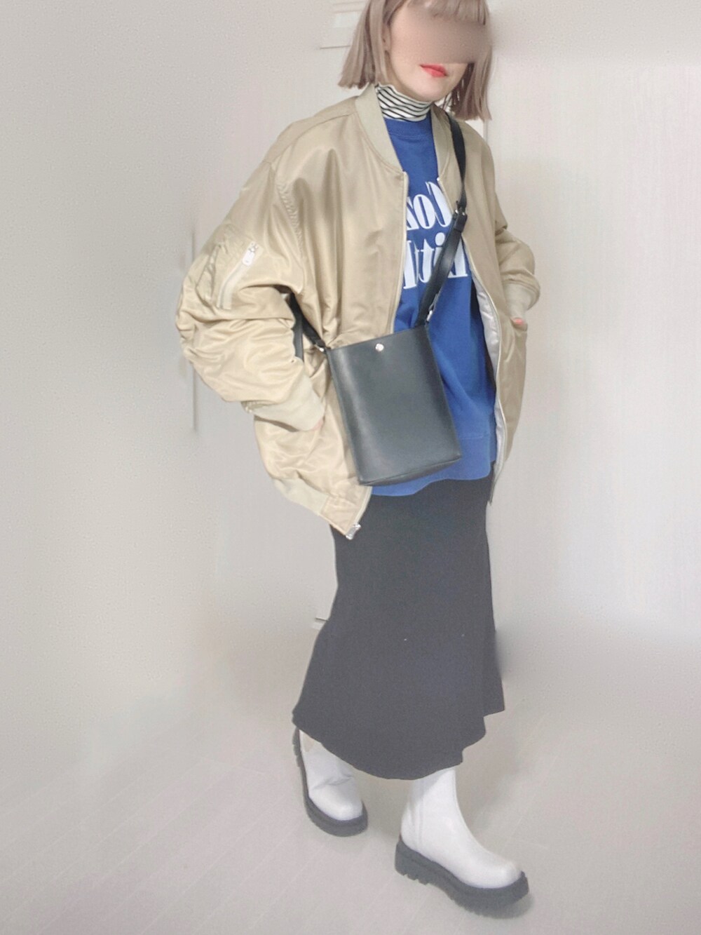 ベージュ系のMA-1、ホワイト系のTシャツ/カットソー、ブルー系のスウェットを着用したレディースの冬コーディネートの3枚目の写真