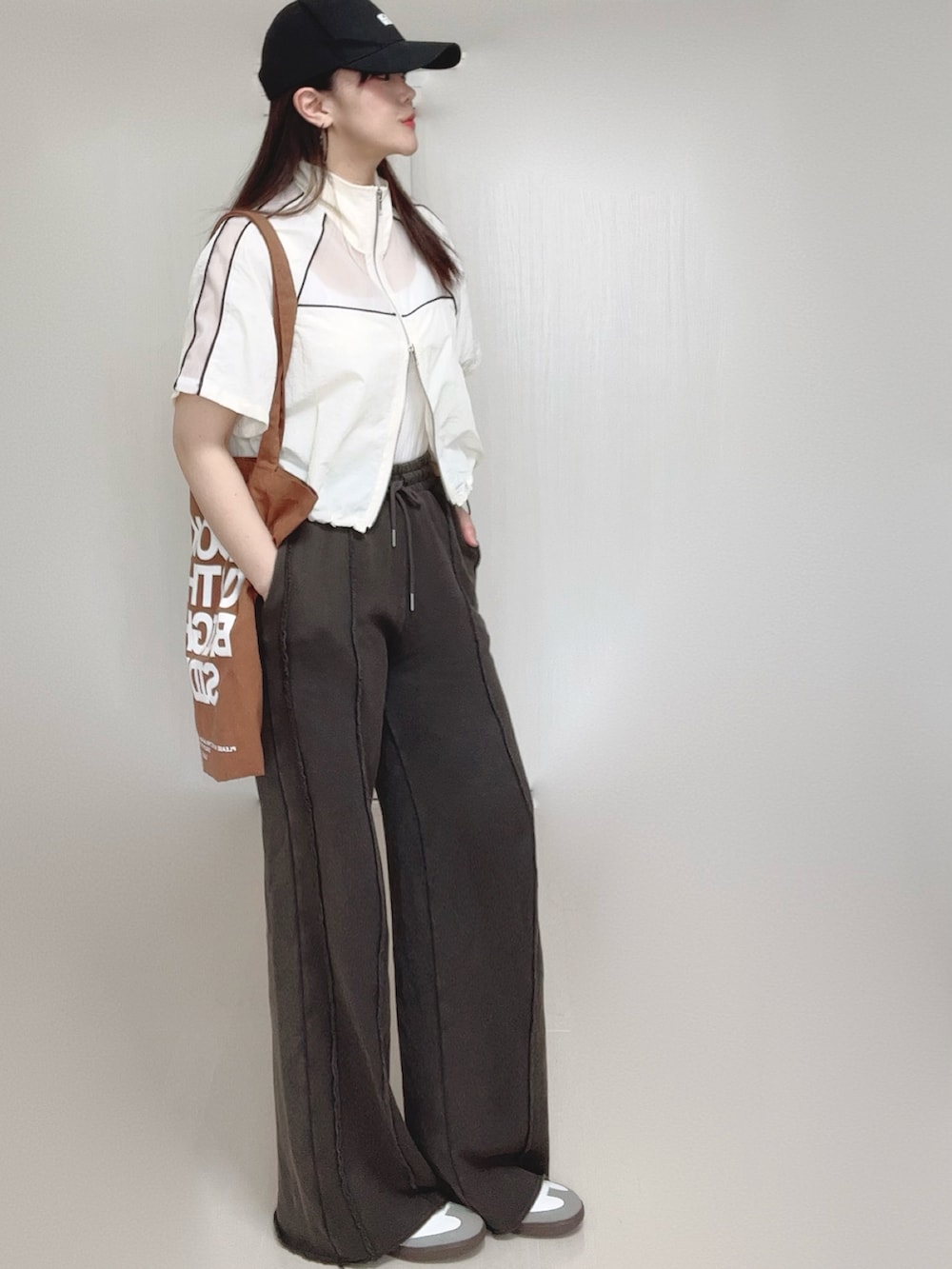 ブラック系のスウェットパンツ、ホワイト系のキャミソール、ホワイト系のブルゾンを着用したレディースの春コーディネートの4枚目の写真