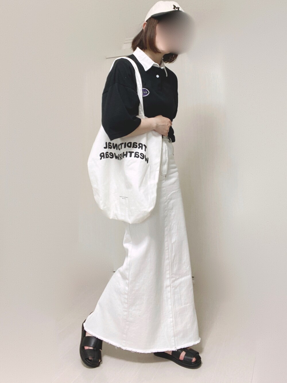 ベージュ系のデニムスカート、ホワイト系のトートバッグ、ブラック系のサンダルを着用したレディースの夏コーディネートの5枚目の写真