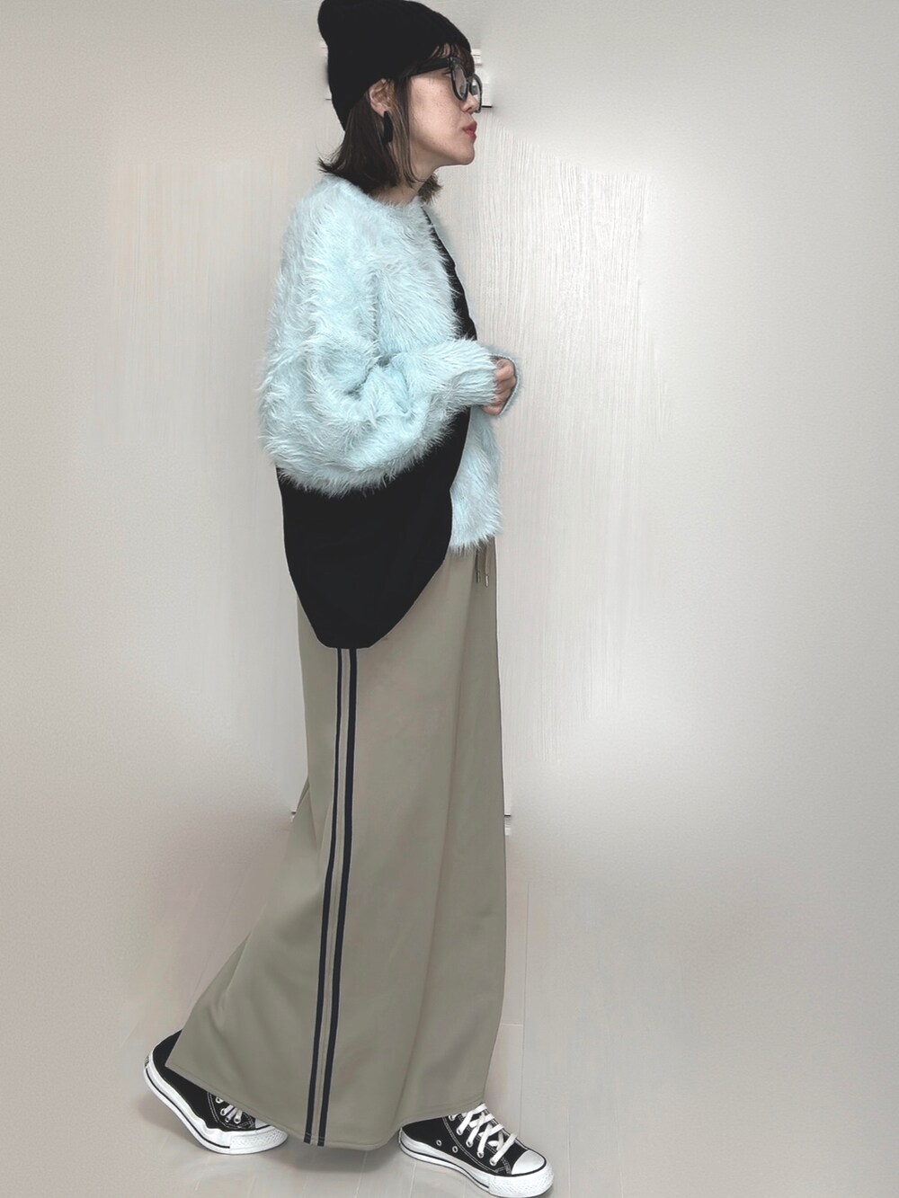 ブルー系のニット/セーター、ブルー系のスカート、ブラック系のスニーカーを着用したレディースの秋コーディネートの4枚目の写真