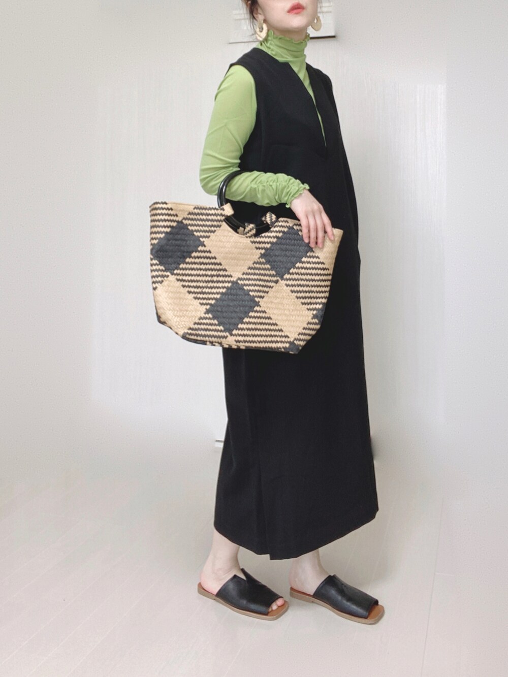 ブラック系のワンピース、ブラック系のトートバッグ、ブラック系のサンダルを着用したレディースの春コーディネートの4枚目の写真