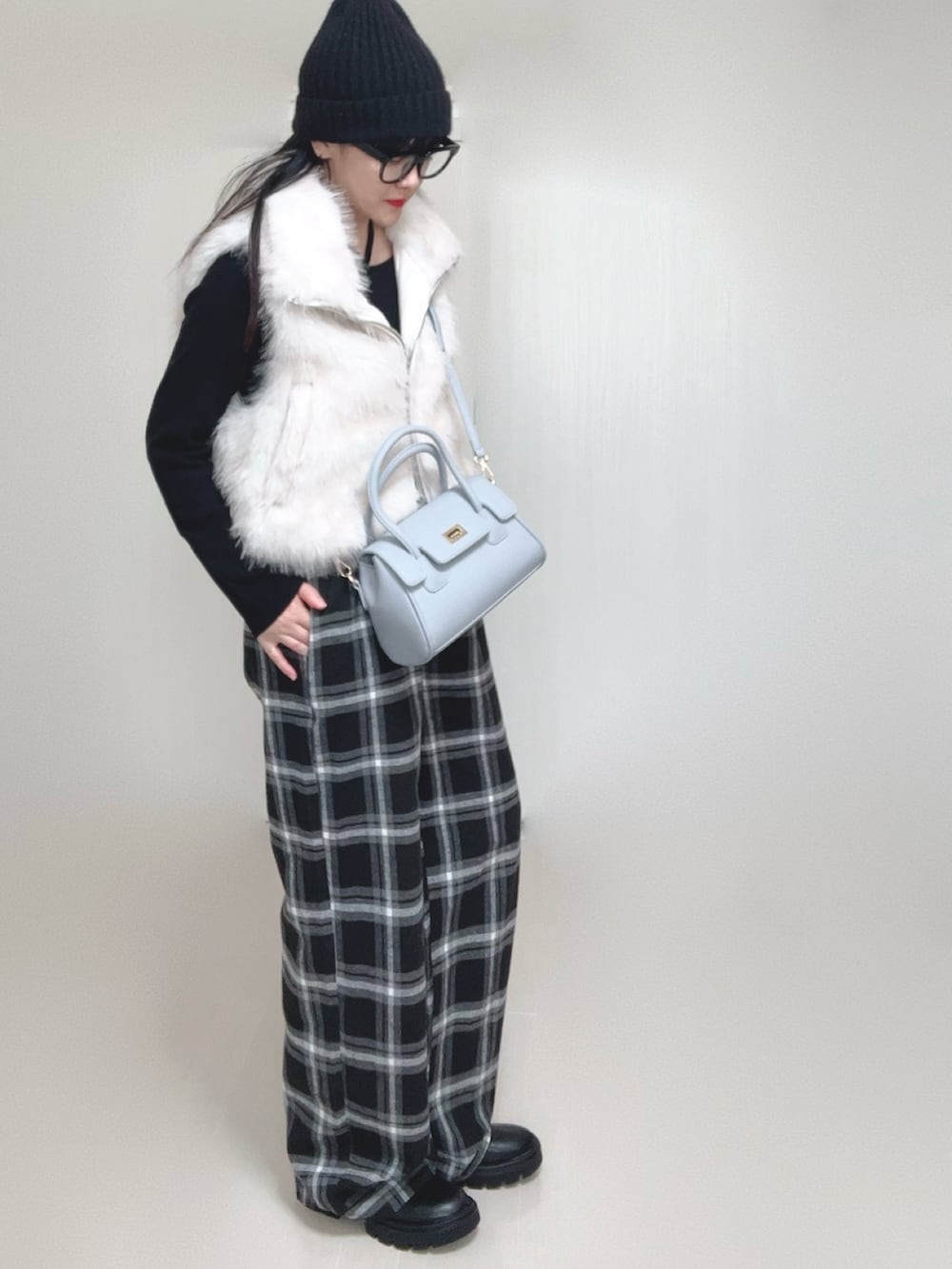 ホワイト系のベスト、ブラック系のTシャツ/カットソー、ブラック系のブーツを着用したレディースの秋コーディネートの3枚目の写真