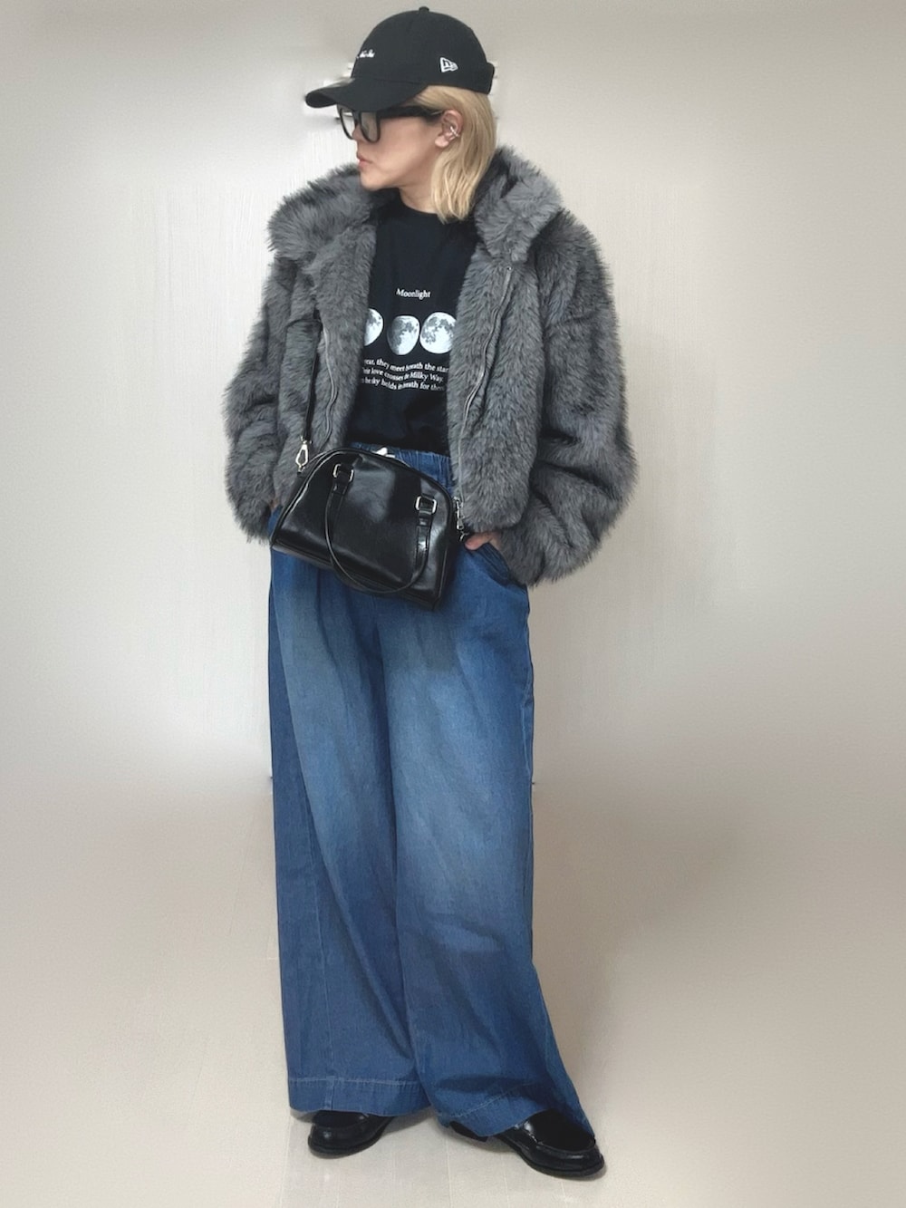 グレー系のブルゾン、ブラック系のTシャツ/カットソー、ブラック系のボストンバッグを着用したレディースの冬コーディネートの4枚目の写真