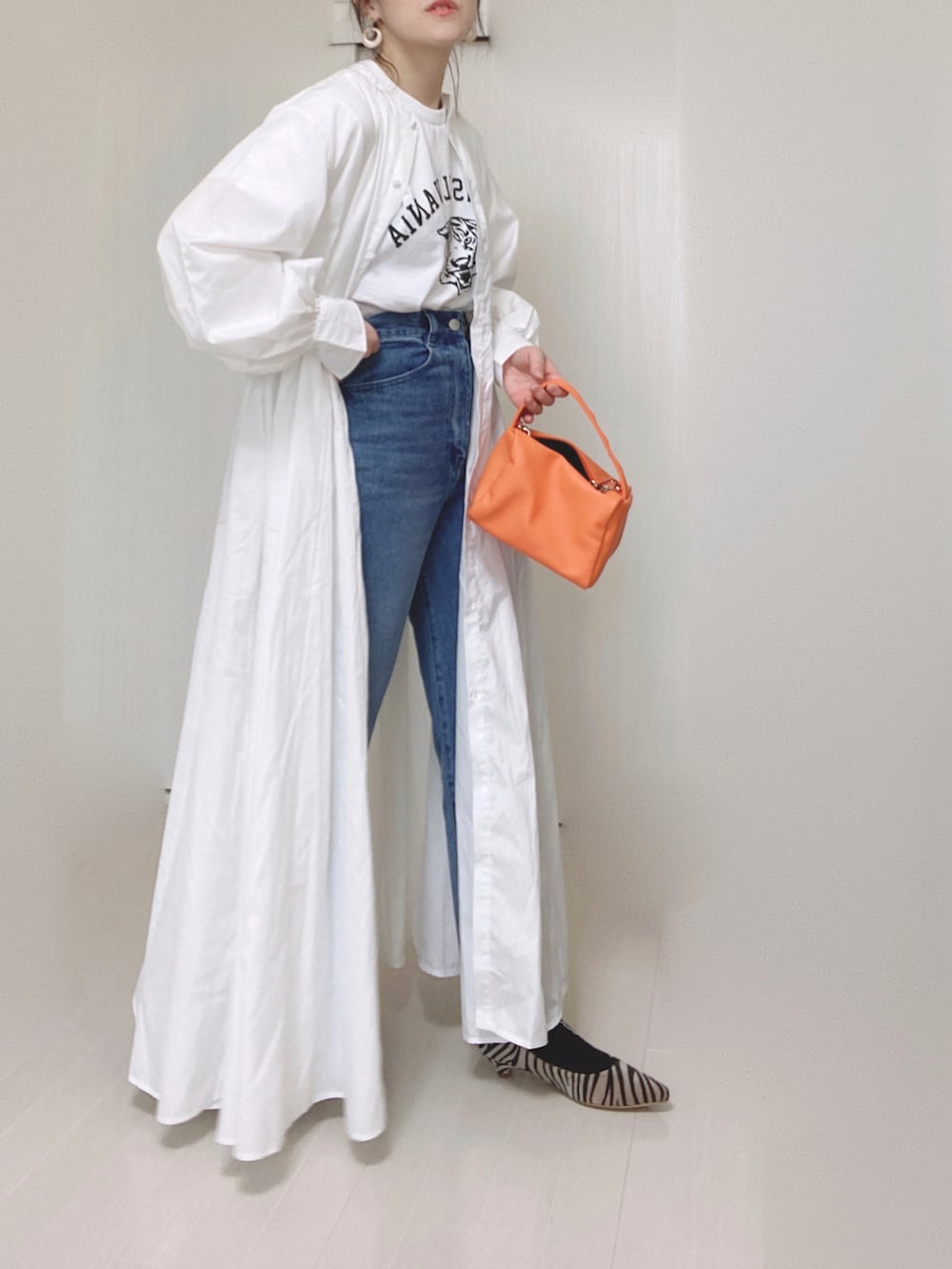 ホワイト系のTシャツ/カットソー、ホワイト系のシャツワンピース、ブルー系のデニムパンツを着用したレディースの春コーディネートの4枚目の写真