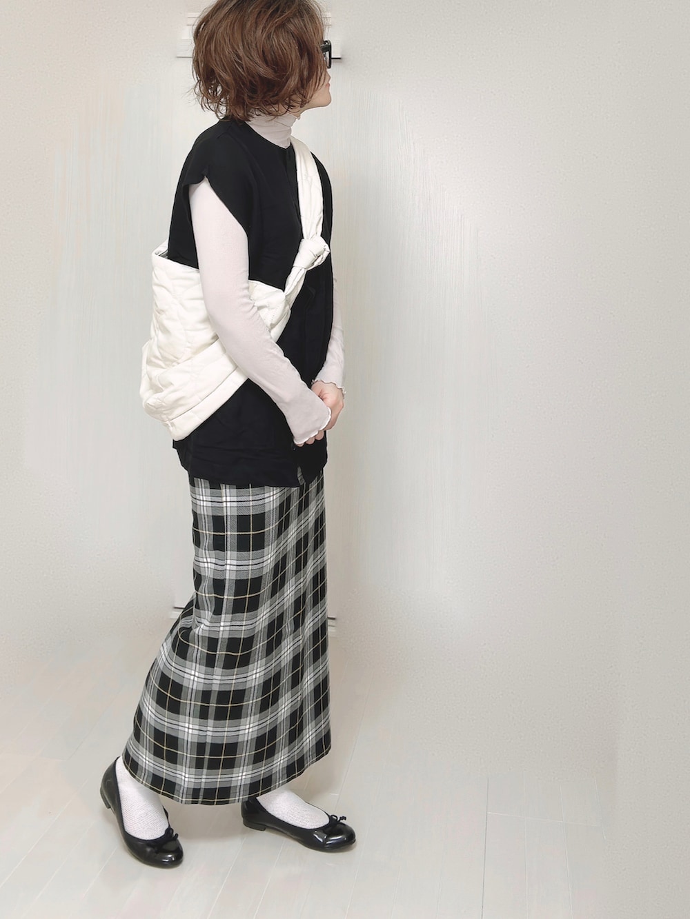 ブラック系のベスト、グレー系のTシャツ/カットソー、ホワイト系のショルダーバッグを着用したレディースの春コーディネートの4枚目の写真