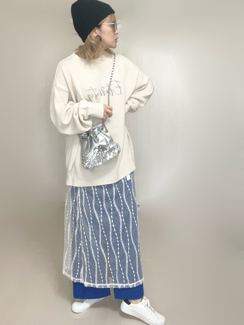 ホワイト系のニット/セーター、シルバー系のショルダーバッグ、ホワイト系のスカートを着用したレディースの秋コーディネートの5枚目の写真