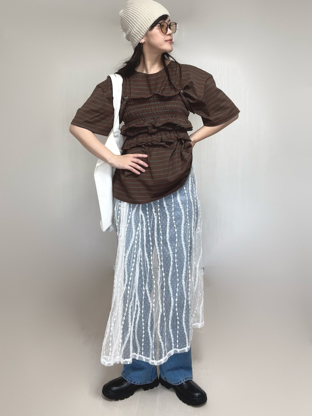 ブラウン系のTシャツ/カットソー、ブルー系のデニムパンツ、ホワイト系のスカートを着用したレディースの夏コーディネートの2枚目の写真