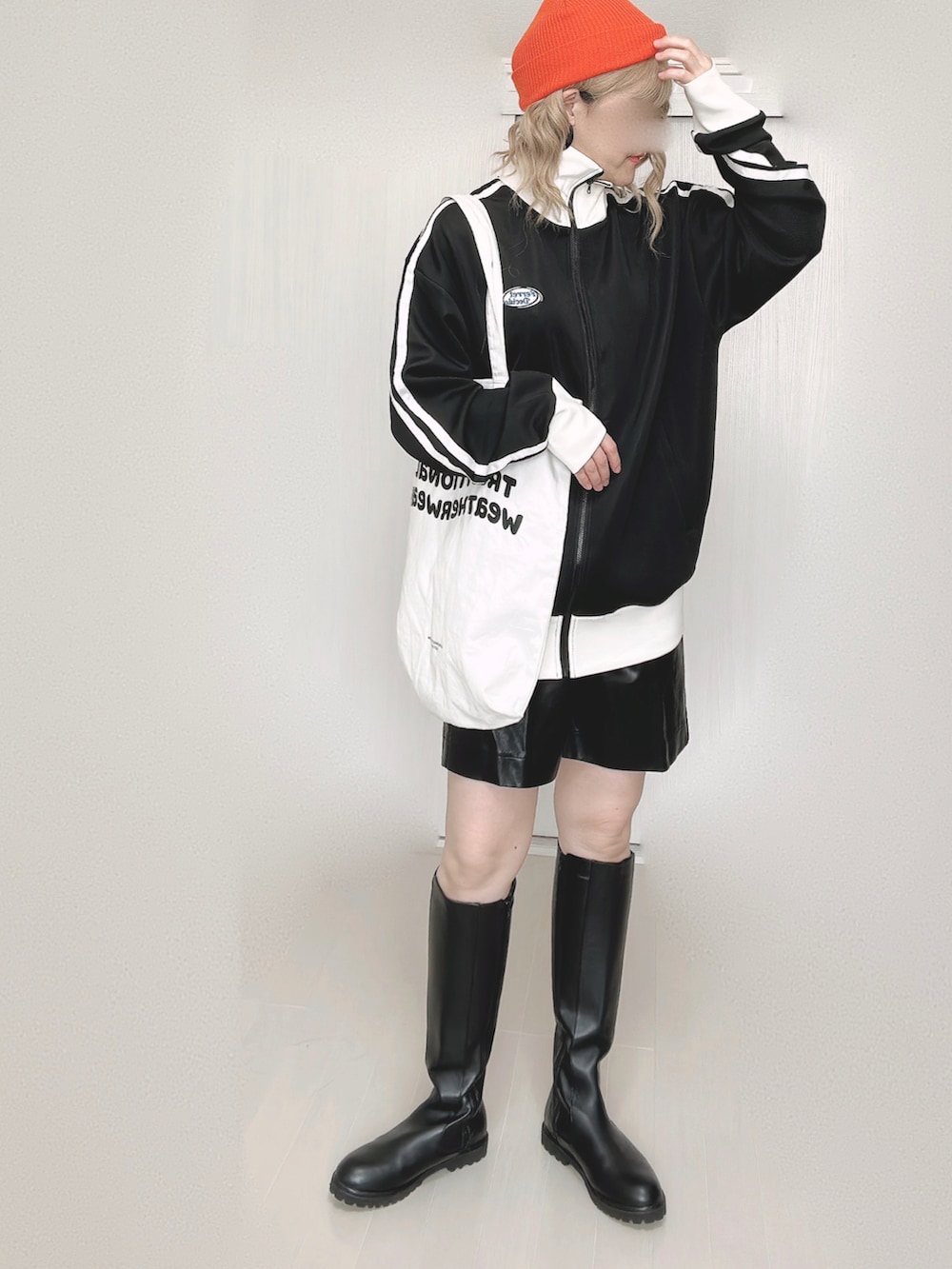 ブラック系のブルゾン、ブルー系のベスト、ホワイト系のトートバッグを着用したレディースの秋コーディネートの3枚目の写真