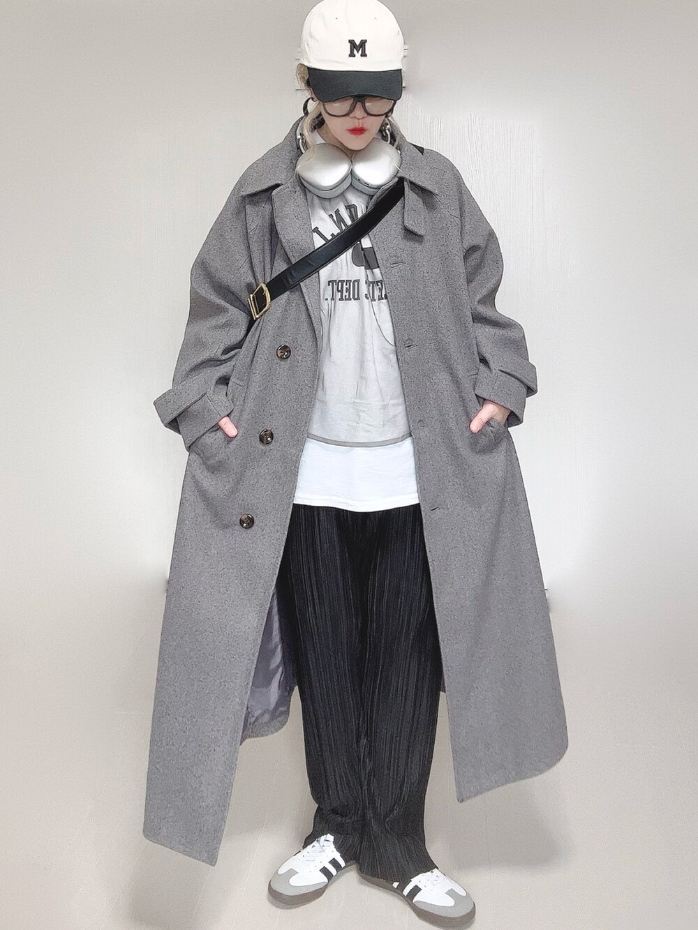 グレー系のステンカラーコート、ホワイト系のTシャツ/カットソー、ブラック系のその他パンツを着用したレディースの冬コーディネートの4枚目の写真