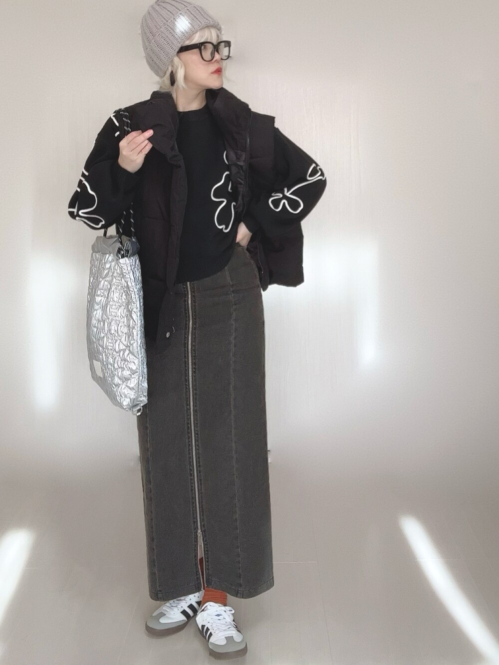 ブラック系のニット/セーター、ブラック系のスカート、ブラック系のダウンベストを着用したレディースの冬コーディネートの4枚目の写真