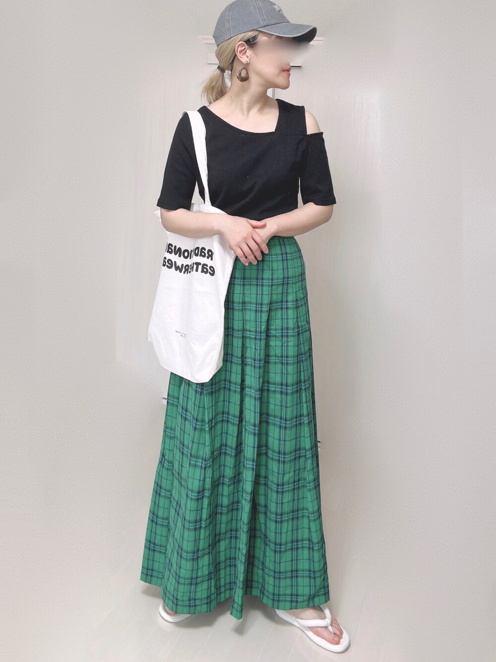 ブラック系のTシャツ/カットソー、ホワイト系のトートバッグ、グリーン系のスカートを着用したレディースの夏コーディネートの3枚目の写真
