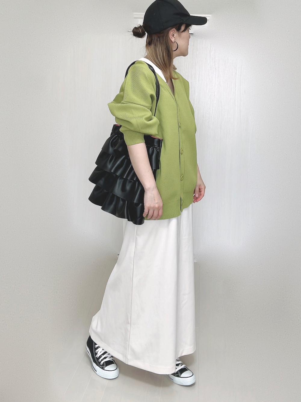 グリーン系のカーディガン/ボレロ、ホワイト系のワンピース、ブラック系のスニーカーを着用したレディースの秋コーディネートの5枚目の写真