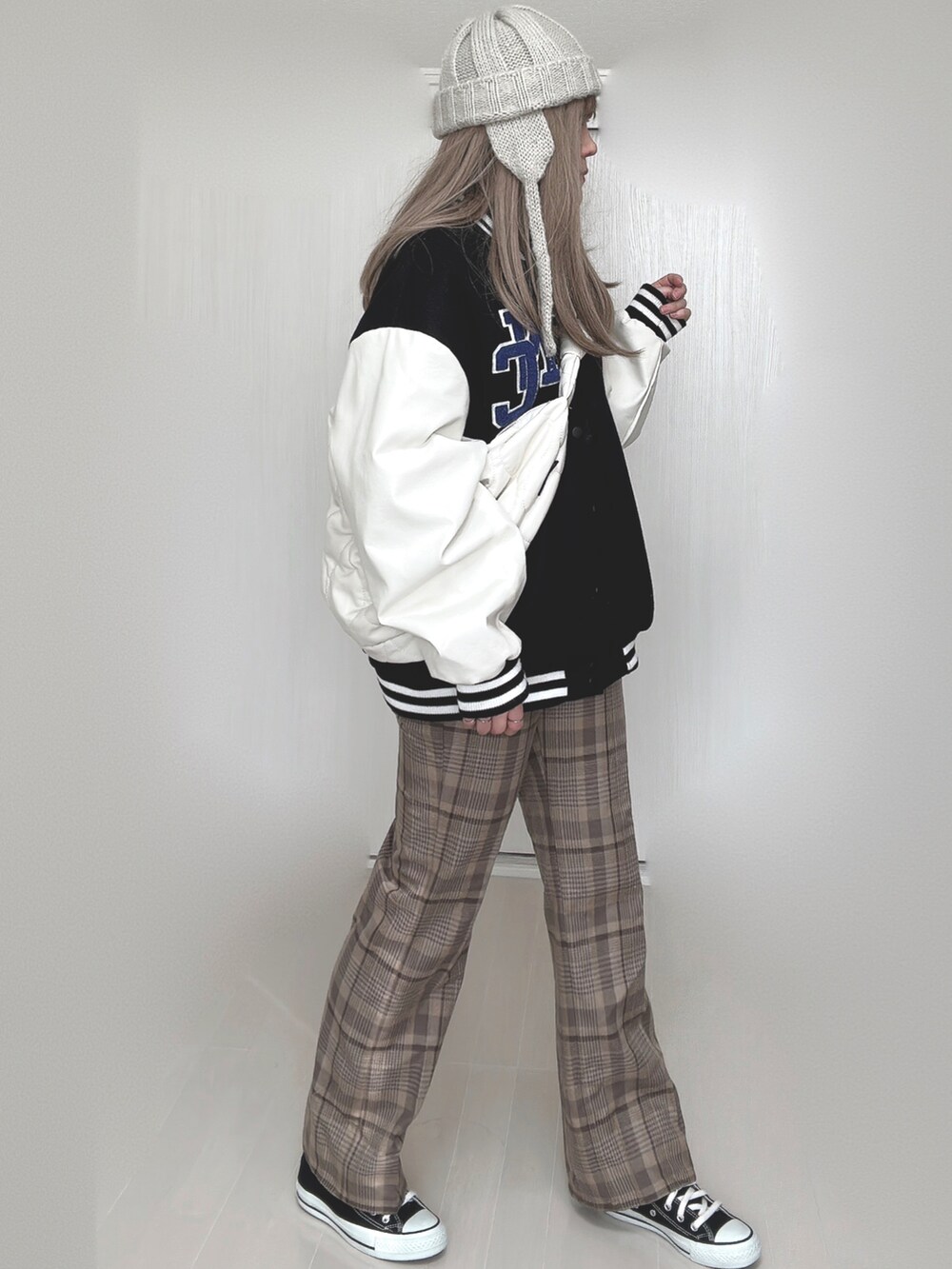 ブラック系のスタジャン、ホワイト系のショルダーバッグ、ベージュ系のその他パンツを着用したレディースの秋コーディネートの4枚目の写真