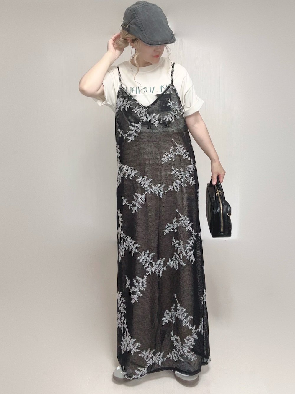 ベージュ系のスラックス、ブラック系のワンピース、ホワイト系のTシャツ/カットソーを着用したレディースの夏コーディネートの2枚目の写真