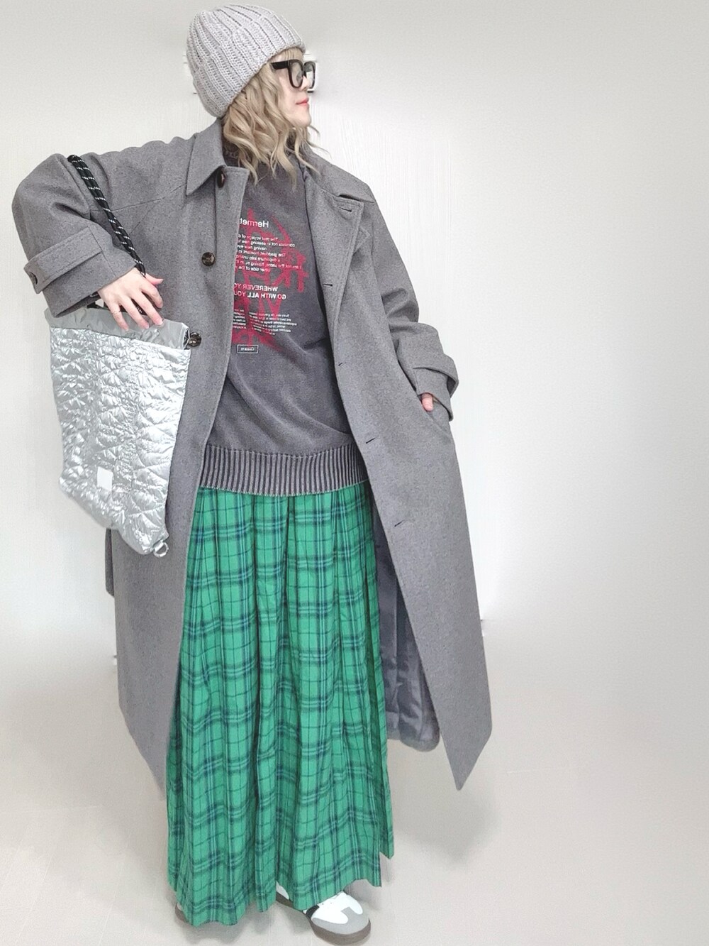 ブラック系のニット/セーター、グレー系のステンカラーコート、シルバー系のトートバッグを着用したレディースの春コーディネートの4枚目の写真