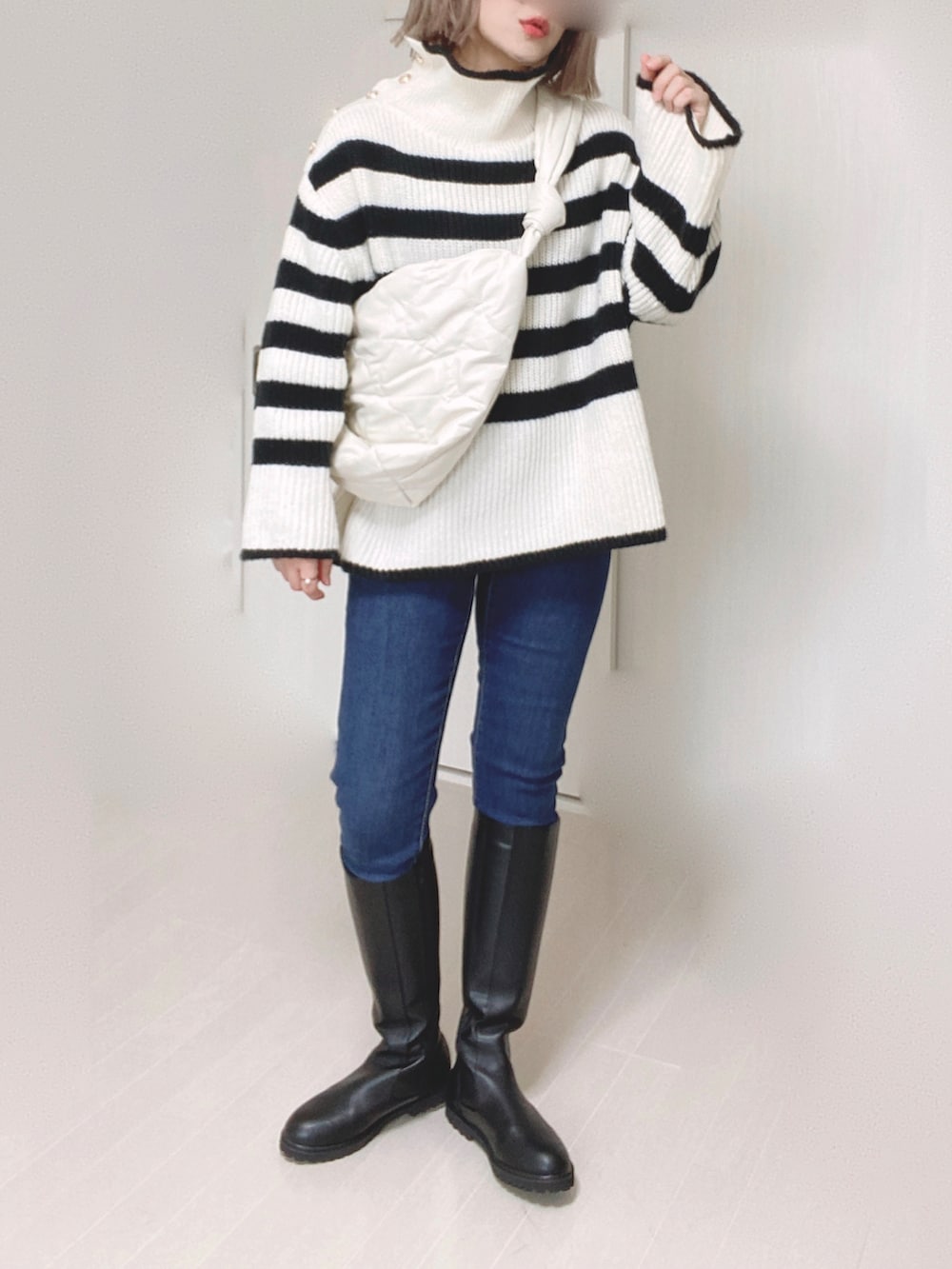 ブラック系のブーツ、ホワイト系のニット/セーター、ホワイト系のショルダーバッグを着用したレディースの秋コーディネートの5枚目の写真