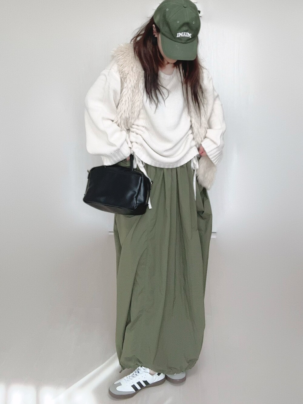 ホワイト系のニット/セーター、ホワイト系のベスト、ブラック系のボストンバッグを着用したレディースの秋コーディネートの5枚目の写真