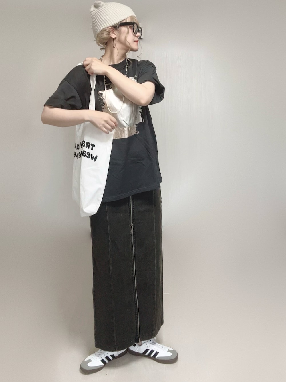 ブラック系のTシャツ/カットソー、ブラック系のスカート、ホワイト系のトートバッグを着用したレディースの夏コーディネートの2枚目の写真