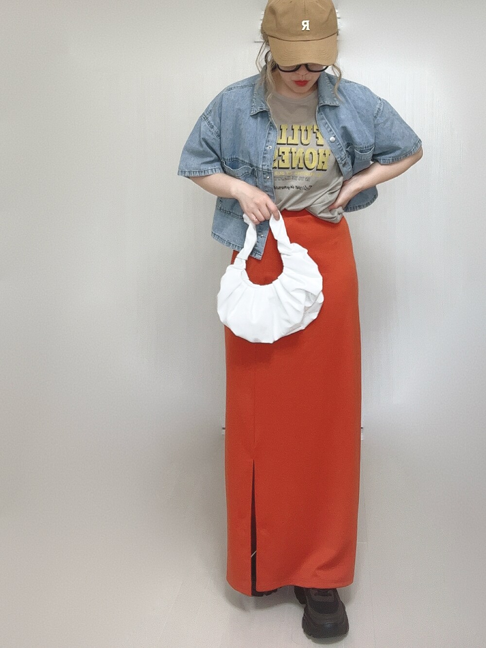 ブルー系のシャツ/ブラウス、オレンジ系のスカート、ブラック系のスニーカーを着用したレディースの夏コーディネートの4枚目の写真