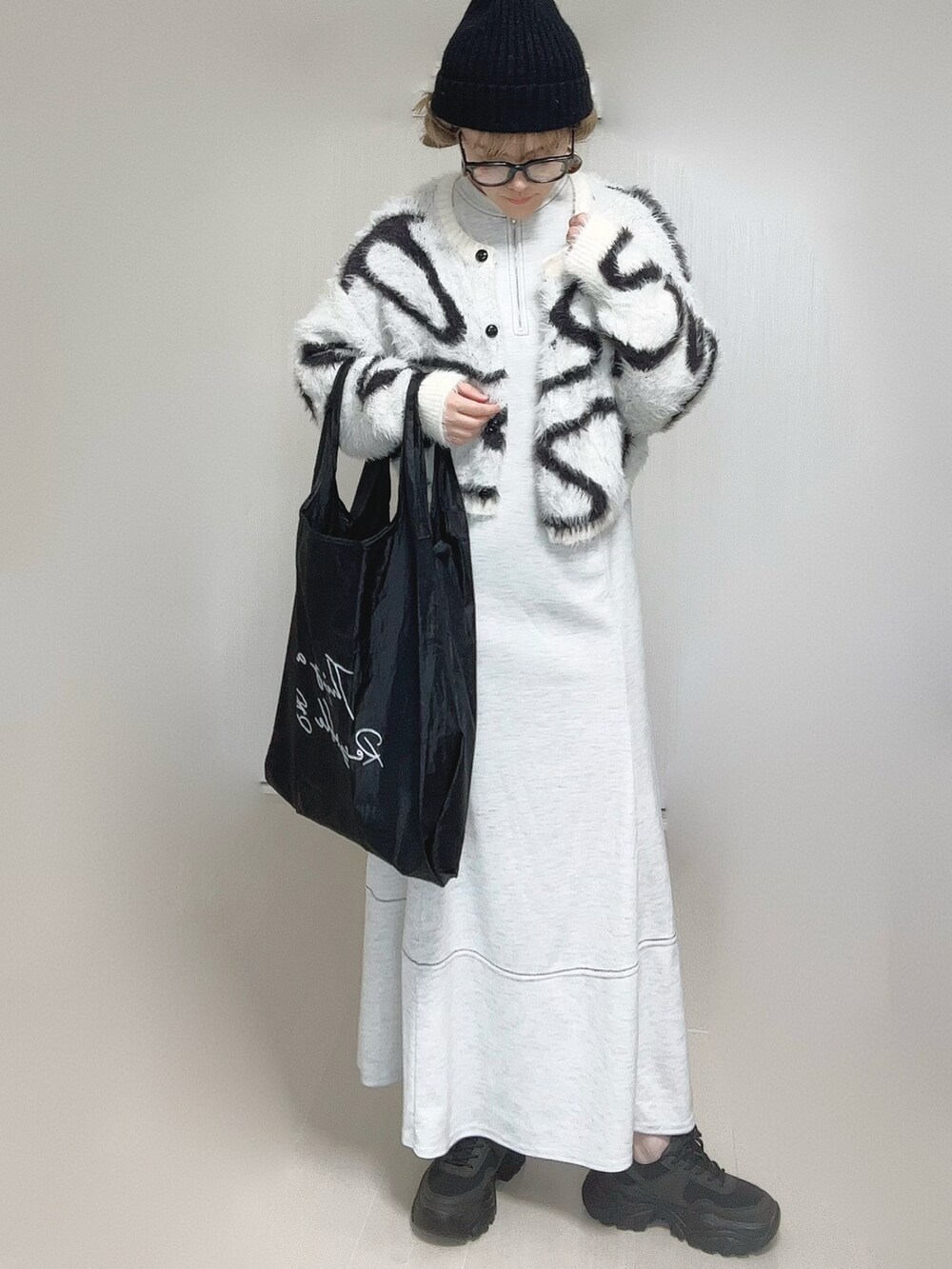 グレー系のワンピース、ホワイト系のカーディガン/ボレロ、グレー系のエコバッグ/サブバッグを着用したレディースの秋コーディネートの3枚目の写真