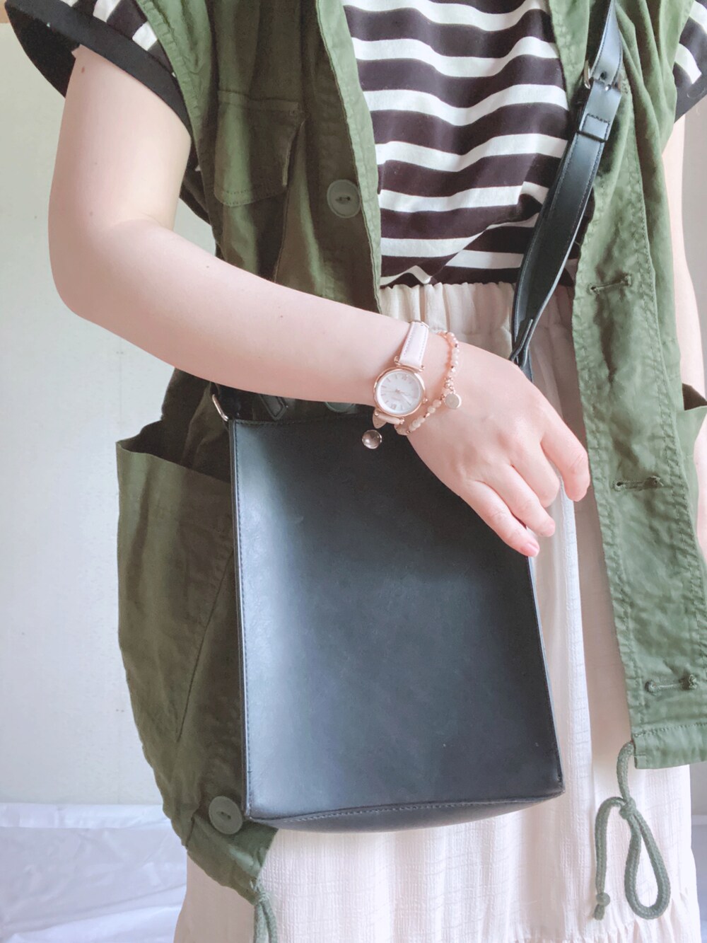 ホワイト系のTシャツ/カットソー、ホワイト系のスカート、ブラック系のショルダーバッグを着用したレディースの春コーディネートの2枚目の写真