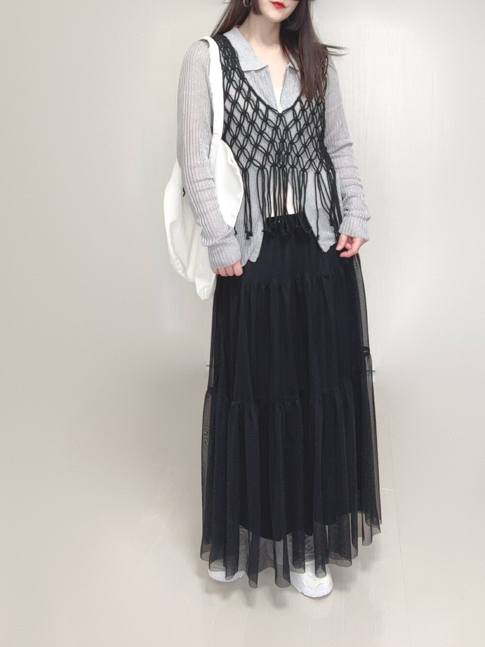 グレー系のカーディガン/ボレロ、ブラック系のスカート、ブラック系のベストを着用したレディースの春コーディネートの4枚目の写真