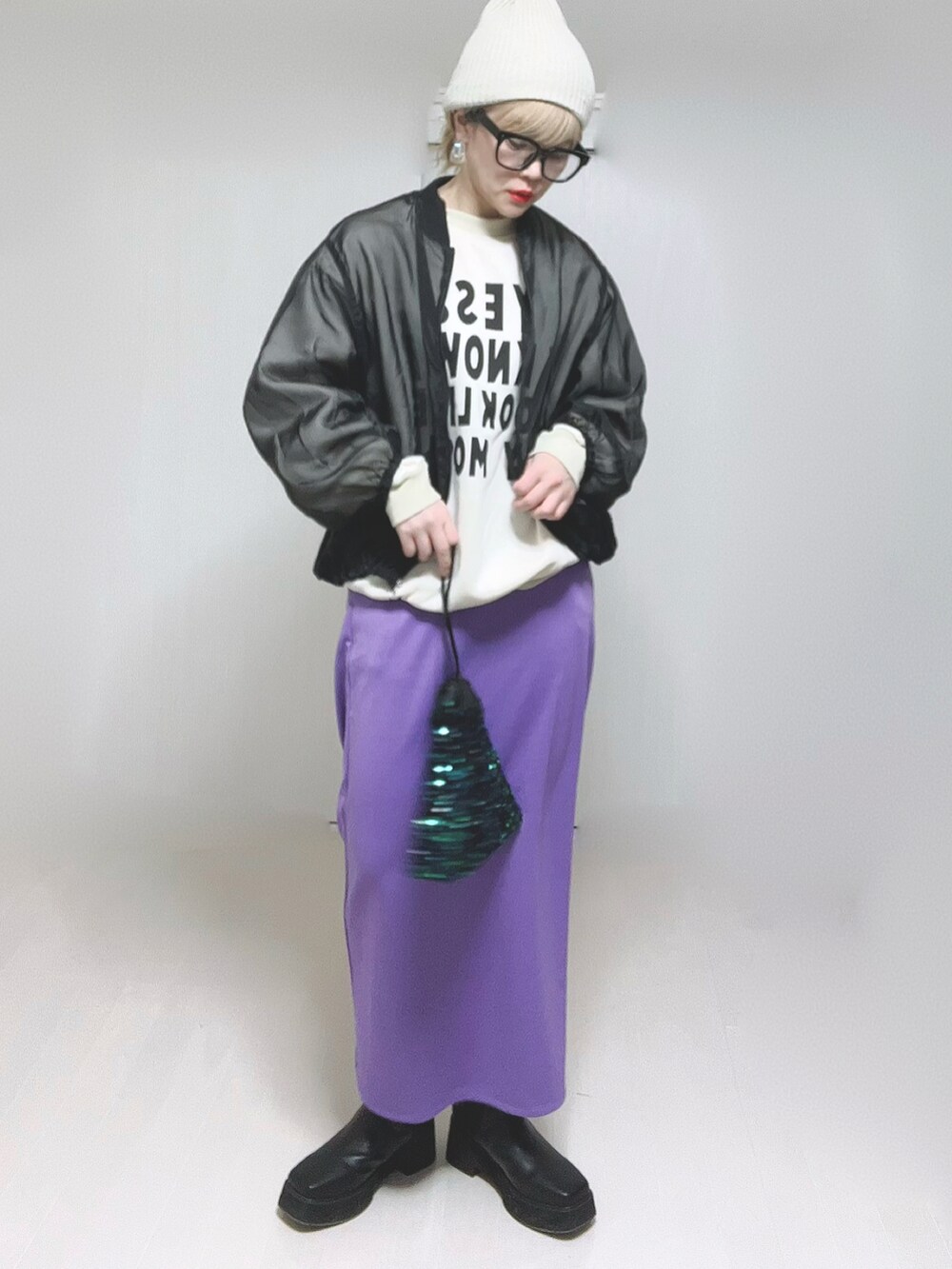 パープル系のスカート、ブラック系のブーツを着用したレディースの冬コーディネートの2枚目の写真