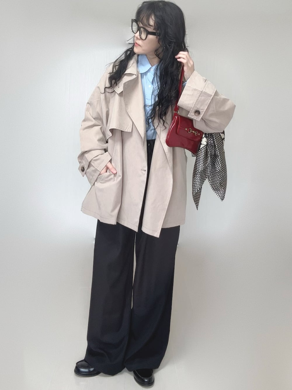 ベージュ系のトレンチコート、ブラック系のスラックス、ブラック系のローファーを着用したレディースの春コーディネートの5枚目の写真