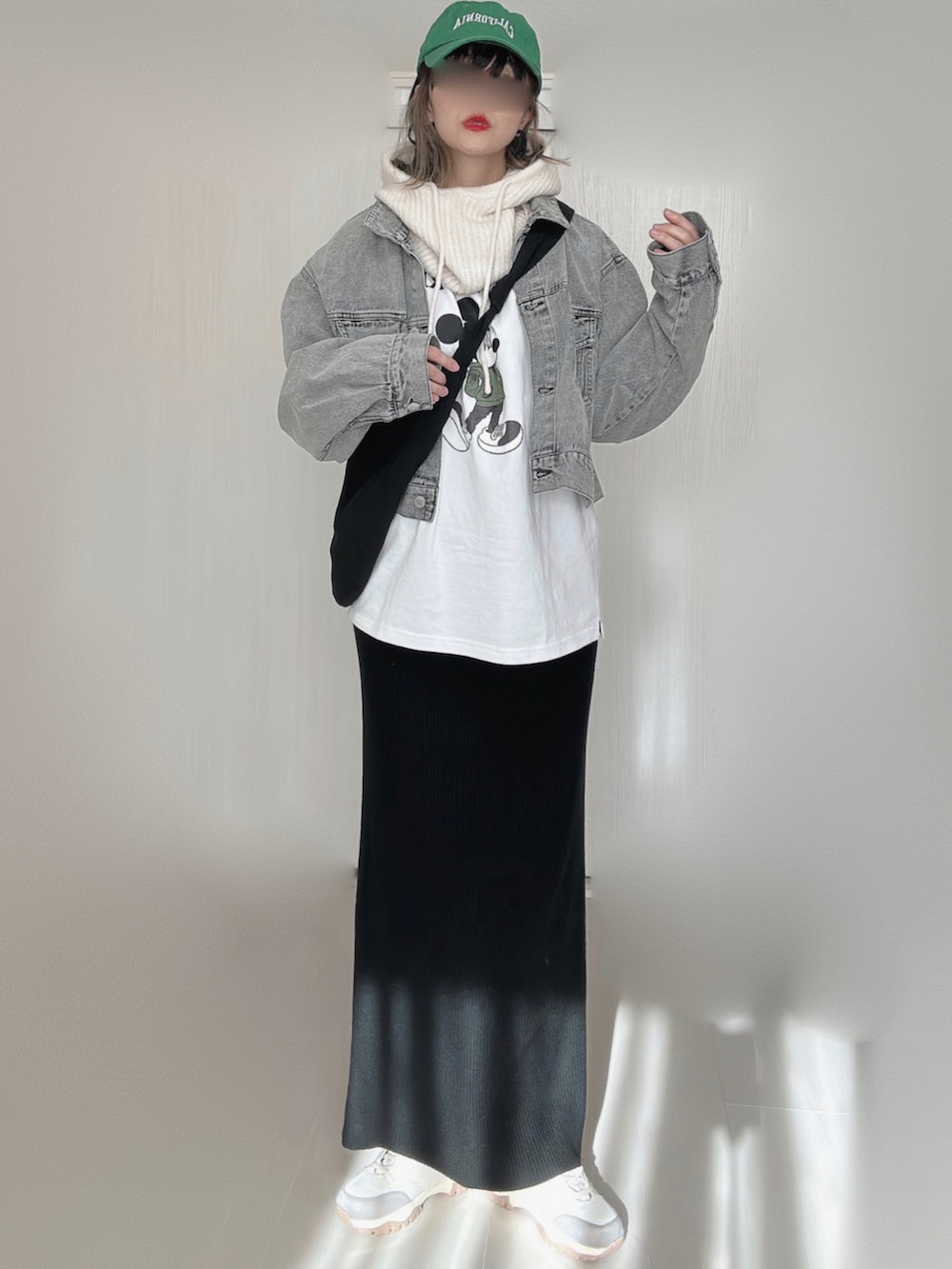 ブラック系のデニムジャケット、ホワイト系のTシャツ/カットソー、ブラック系のスカートを着用したレディースの冬コーディネートの4枚目の写真