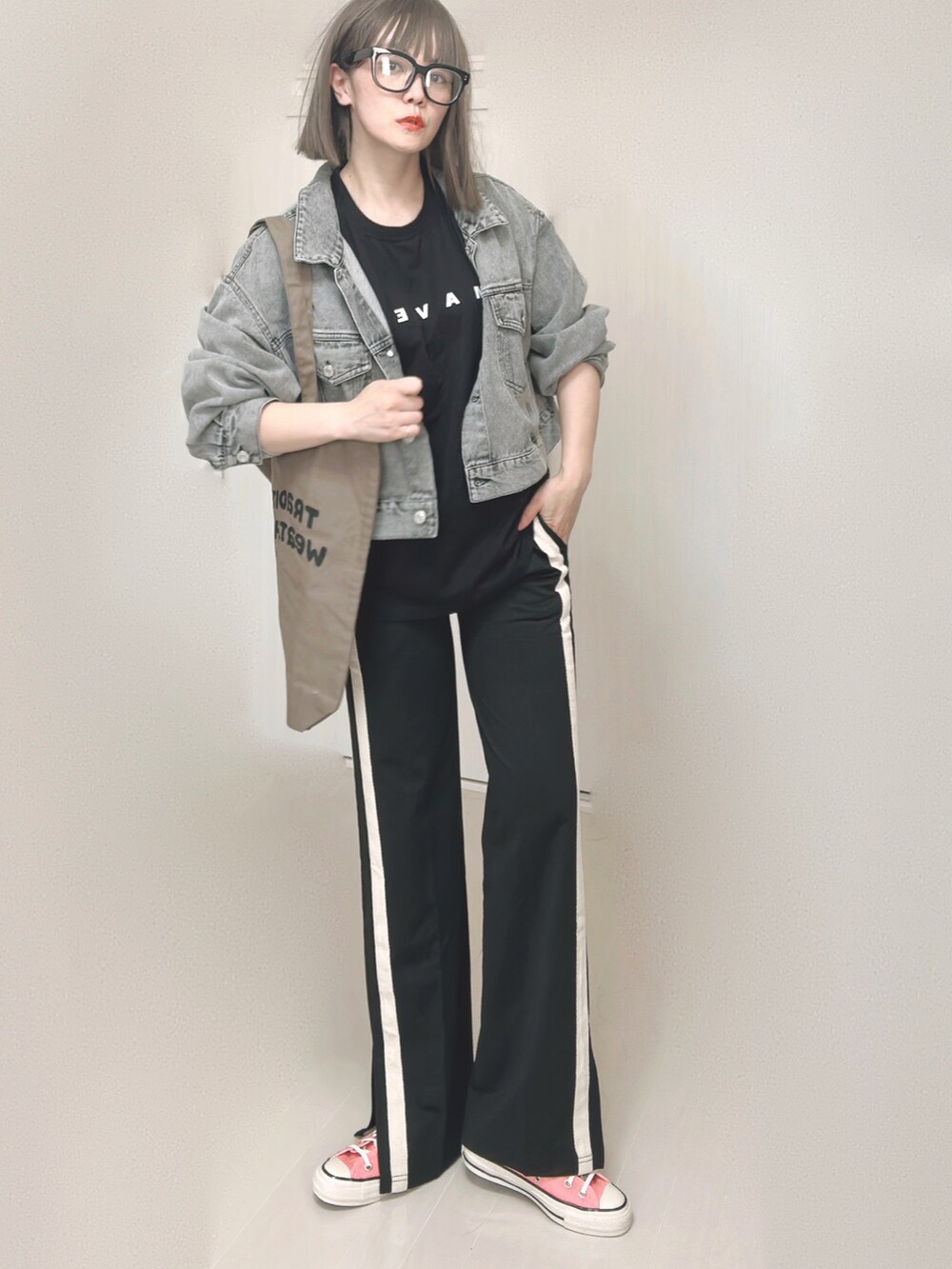 ブラック系のTシャツ/カットソー、ブラック系のデニムジャケット、ブラウン系のトートバッグを着用したレディースの秋コーディネートの4枚目の写真