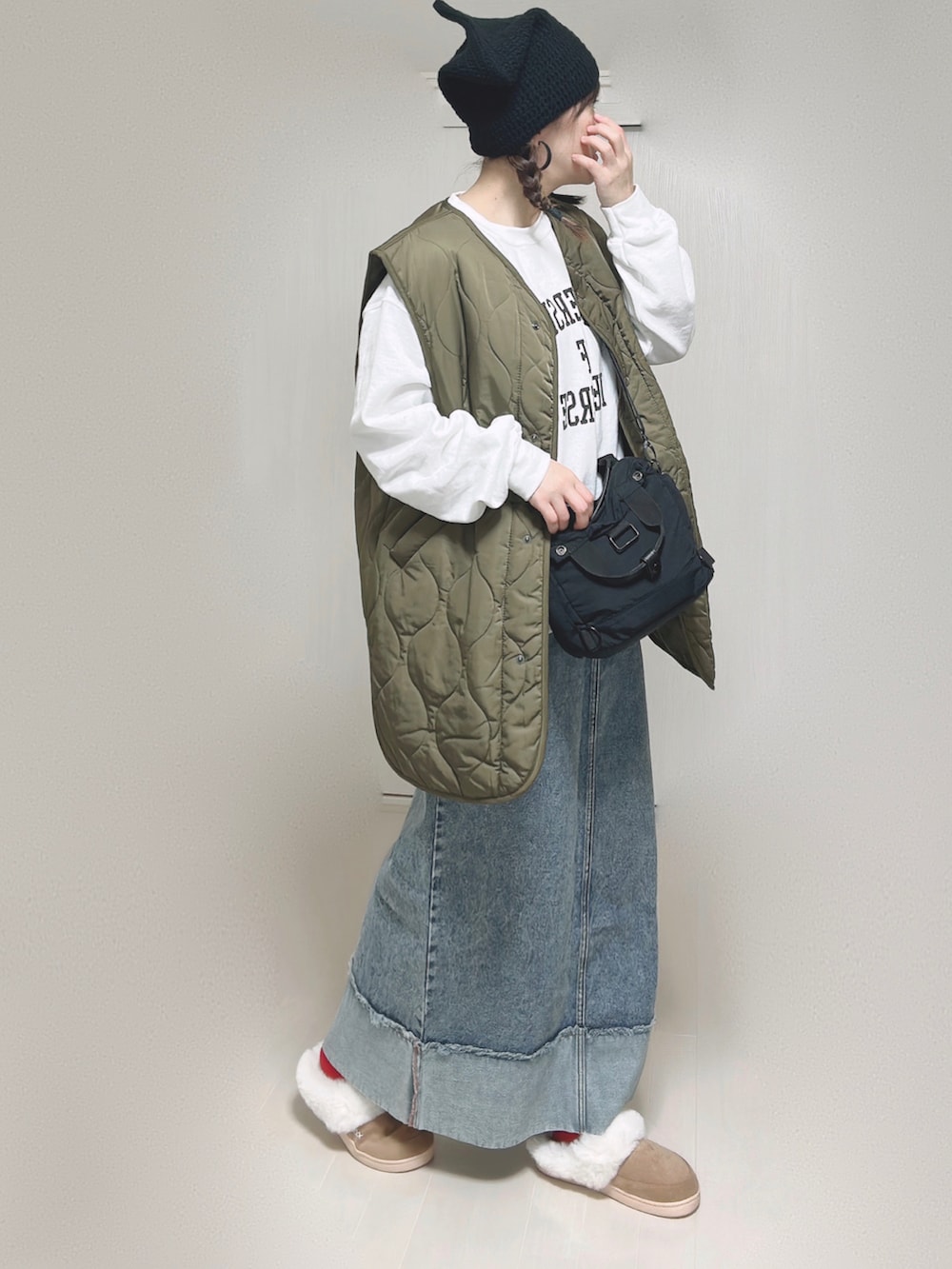 ベージュ系のMA-1、ホワイト系のスウェット、ブラック系のショルダーバッグを着用したレディースの冬コーディネートの4枚目の写真