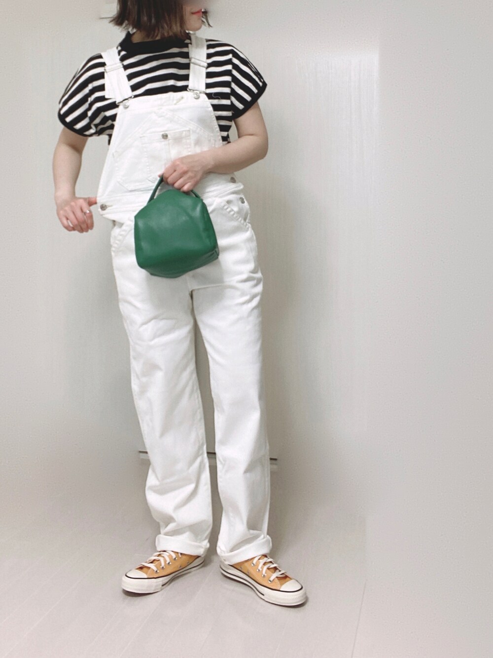 ホワイト系のTシャツ/カットソー、ホワイト系のサロペット/オーバーオール、グリーン系のハンドバッグを着用したレディースの春コーディネートの2枚目の写真
