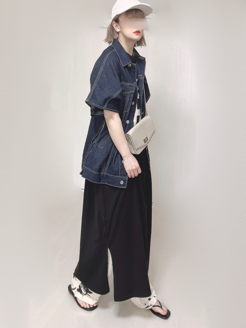 ブルー系のベスト、ベージュ系のショルダーバッグ、ブラック系のサンダルを着用したレディースの春コーディネートの4枚目の写真